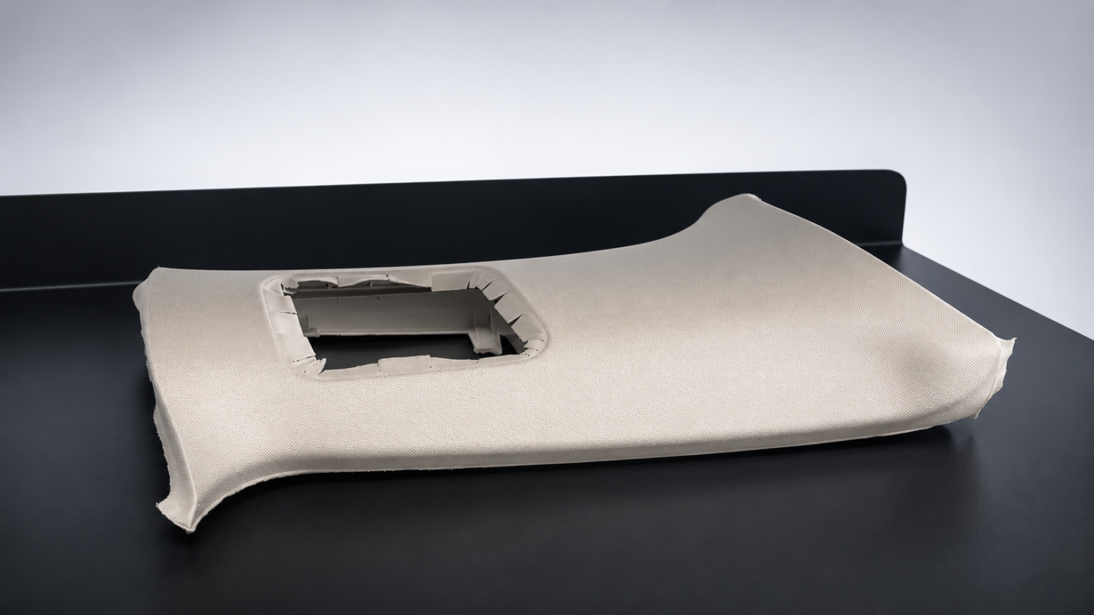 Bauteil hergestellt mit Stoffhinterspritzen bei MÜLLER WALLAU. Alkantara oder Stoffe als Dekormaterial. Fertigung mithilfe von Umbugschieber.